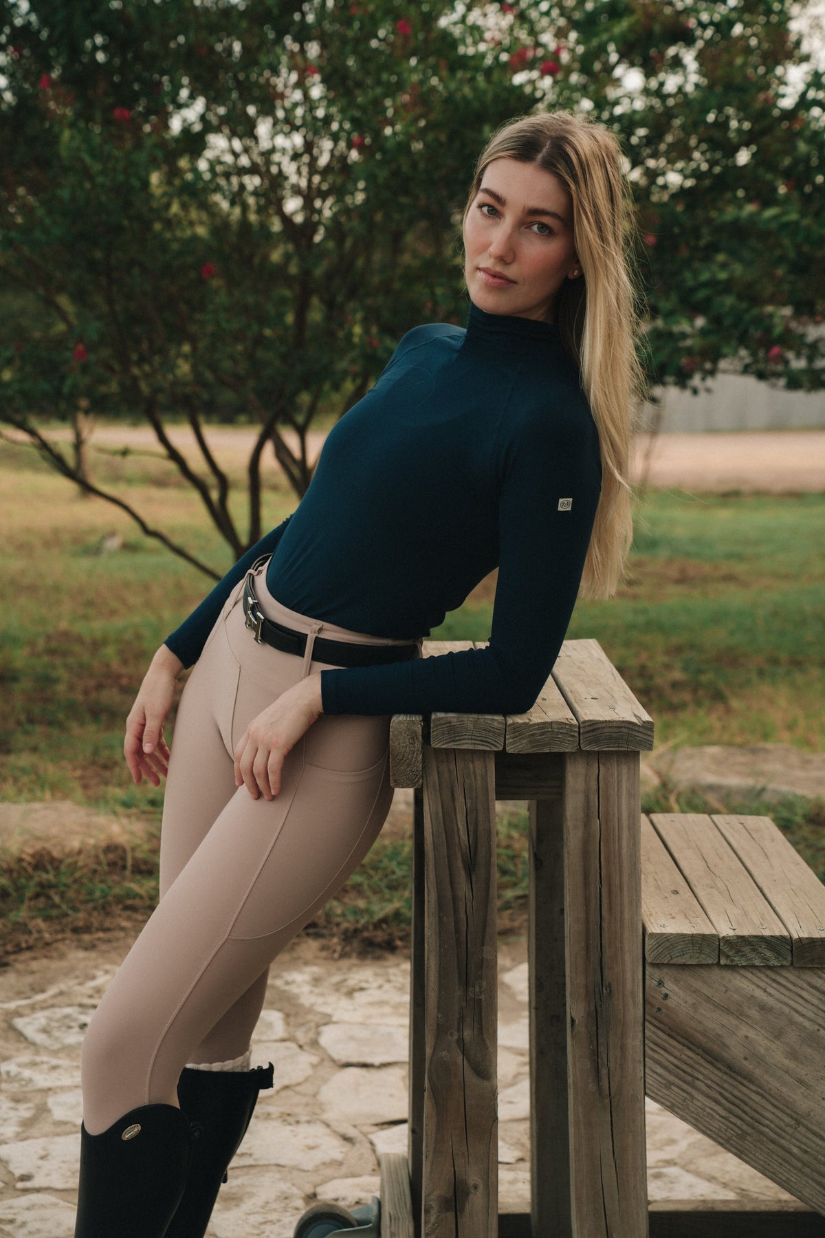 Navy Mia Mock Neck, side view leaning on a bench