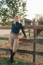 Rider in the navy Mia Mock Neck by the paddock fence