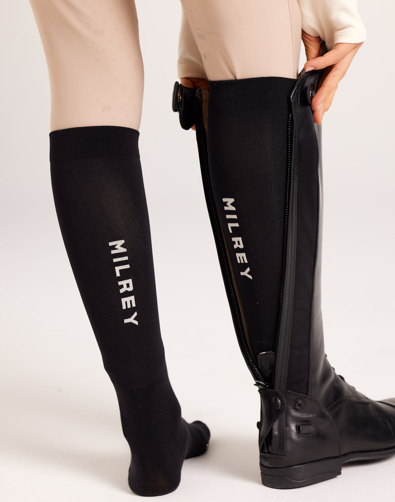 Women's knee-high technical riding socks in breathable cotton blend, featuring compression support and moisture-wicking properties for equestrian activities.