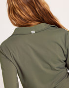 Milrey Callie long sleeve riding blouse in olive green, worn by a model — technical equestrian polo blouse.