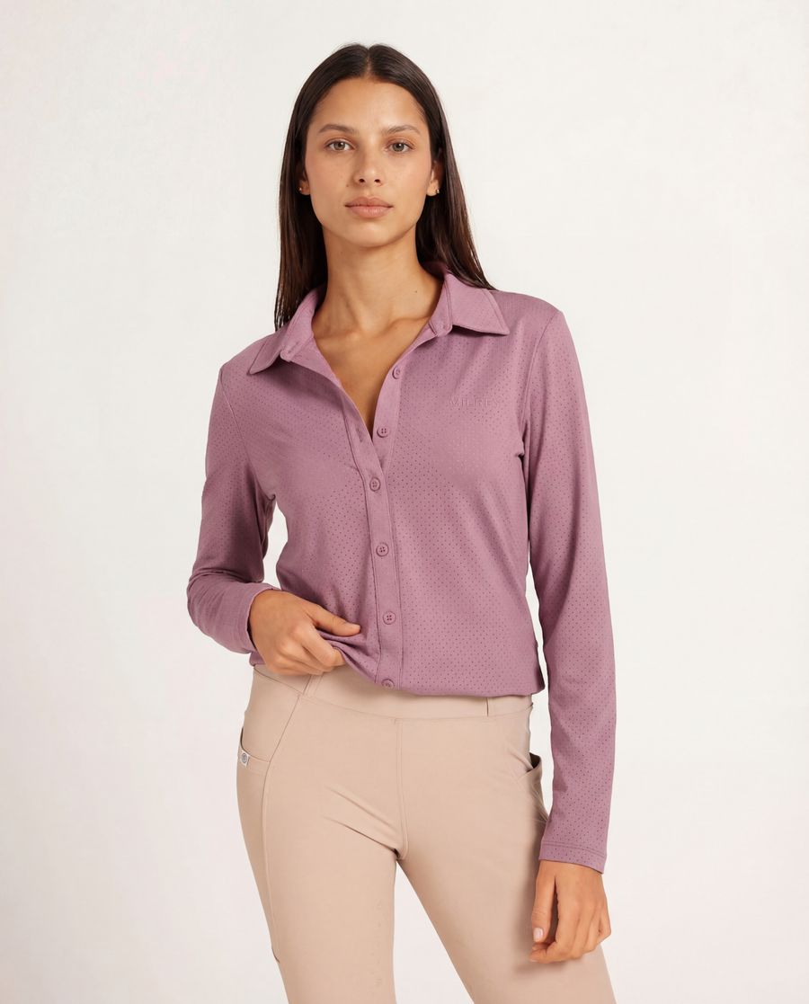 Woman wearing a pink shirt with a perforated pattern on a white background