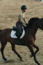 Rider in the khaki Mia Mock Neck riding a bay horse